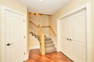 Stairs with baseboards and wood finished floors