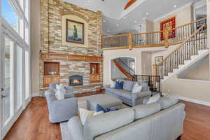 Living room with stairway, a towering ceiling, baseboards, and wood finished floors