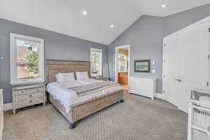Carpeted bedroom with ensuite bath, baseboards, lofted ceiling, and recessed lighting