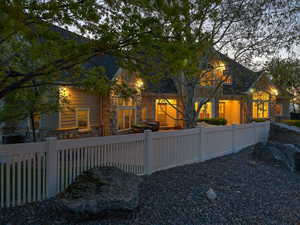 Back of house featuring stone siding and a fenced front yard