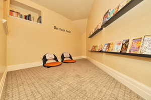Unfurnished room featuring lofted ceiling, baseboards, and carpet floors