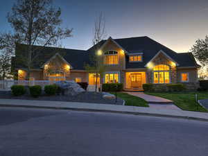 Craftsman-style house with stone siding, a shingled roof, and a front yard