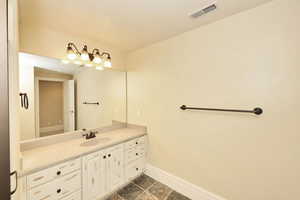 Bathroom featuring baseboards, visible vents, and vanity