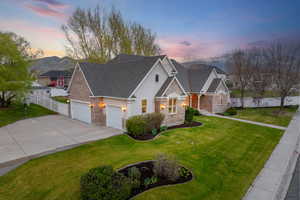 View of front facade with fence, driveway, and yard