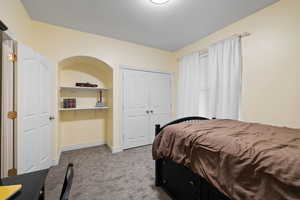 Carpeted bedroom featuring baseboards and a closet