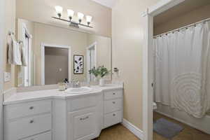 Full bath featuring shower / tub combo with curtain, toilet, vanity, and tile patterned floors