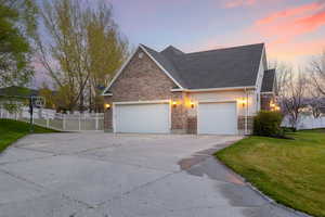 Traditional-style home with fence, a yard, stucco siding, concrete driveway, and a garage