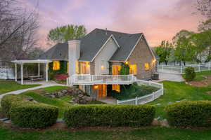 Back of house at dusk featuring a pergola, a fenced backyard, central AC, a patio, and a deck