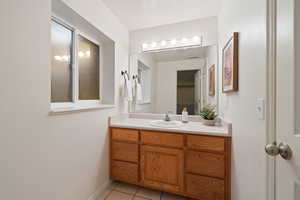 Bathroom with baseboards, vanity, and tile patterned flooring