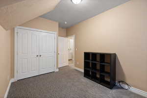 Bedroom featuring a closet, carpet, a textured ceiling, and baseboards