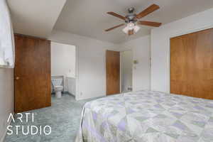 Carpeted bedroom with a closet, a ceiling fan, ensuite bath, and visible vents