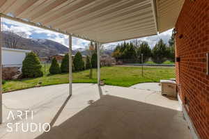 View of patio with fence and a mountain view