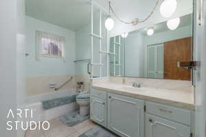 Full bath featuring toilet, a garden tub, vanity, and tile patterned flooring