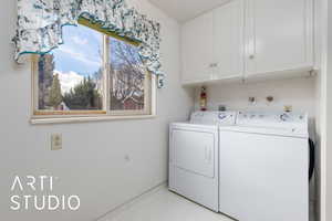 Washroom featuring independent washer and dryer and cabinet space