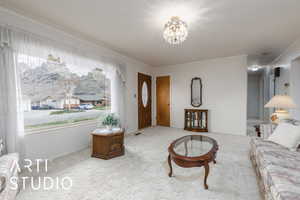 Carpeted living room featuring a notable chandelier, ornamental molding, and visible vents