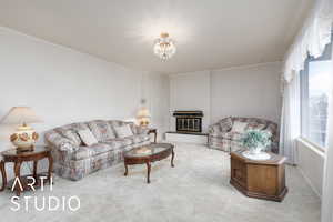 Living area featuring crown molding, an inviting chandelier, carpet, and a healthy amount of sunlight