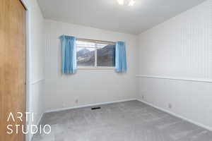 Carpeted empty room with visible vents, baseboards, and wallpapered walls