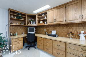 Office area with built in desk and a textured ceiling