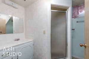Full bathroom with a shower stall and vanity