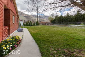 View of yard featuring a mountain view and fence