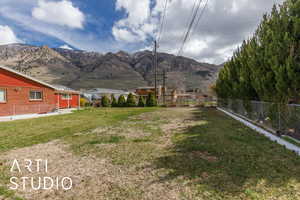 View of yard featuring a mountain view and fence