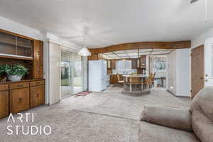 Living area with light carpet and a textured ceiling