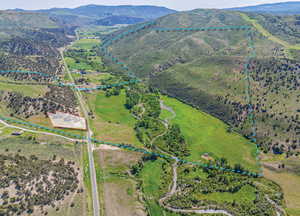 Aerial view of sparsely populated area featuring property parcel outlined and a mountain backdrop
