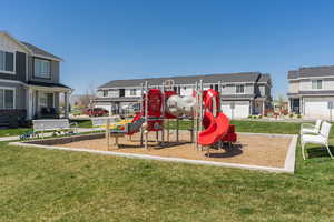 Community play area with a residential view and a lawn