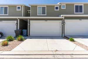 View of property with an attached garage and driveway