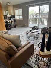 Living room with track lighting, baseboards, and carpet floors