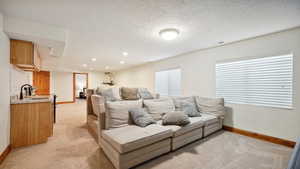 Living room featuring indoor wet bar, light carpet, visible vents, and baseboards