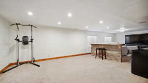 Exercise area featuring recessed lighting, baseboards, and light colored carpet