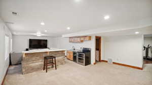 Bar featuring baseboards, visible vents, light colored carpet, and double oven range