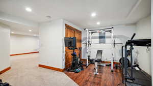 Exercise area featuring dark carpet, baseboards, and recessed lighting