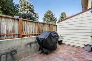 View of patio with fence and area for grilling