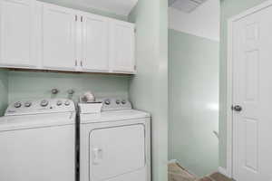 Laundry room with washer and dryer, carpet flooring, baseboards, and cabinet space