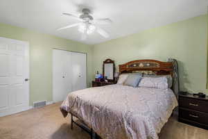 Bedroom with baseboards, a closet, carpet flooring, a ceiling fan, and visible vents
