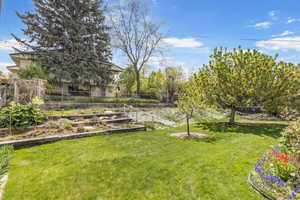 View of yard with fence and a garden