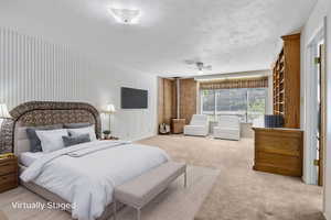 Carpeted bedroom featuring a ceiling fan