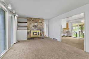 Carpeted living area with visible vents and a fireplace