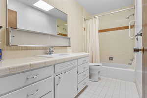 Full bathroom with vanity, tile patterned flooring, toilet, and shower / bathtub combination with curtain