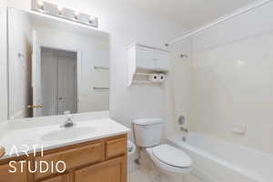 Bathroom featuring vanity, tile patterned flooring,  shower combination, and toilet