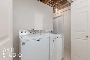 Washroom with light floors, separate washer and dryer, and laundry area
