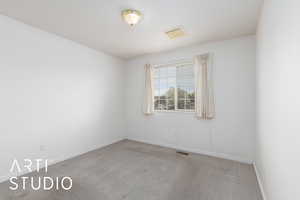 Spare room featuring baseboards, visible vents, and carpet flooring