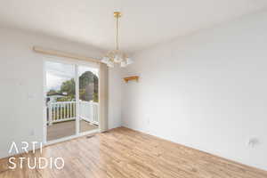 Interior space featuring baseboards, wood finished floors, and a notable chandelier