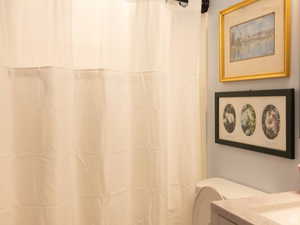 Full bath featuring toilet and curtained shower