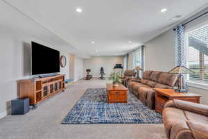 Living area with recessed lighting, visible vents, carpet flooring, and baseboards