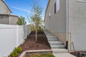 View of yard featuring fence and stairway