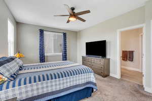 Carpeted bedroom with a ceiling fan and baseboards