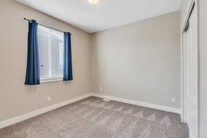 Unfurnished bedroom featuring carpet floors and baseboards